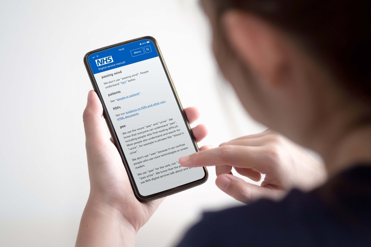 Woman looking at the NHS website on her phone.